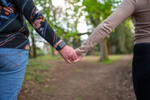Elderly woman in walking in a park with a fall detection watch.